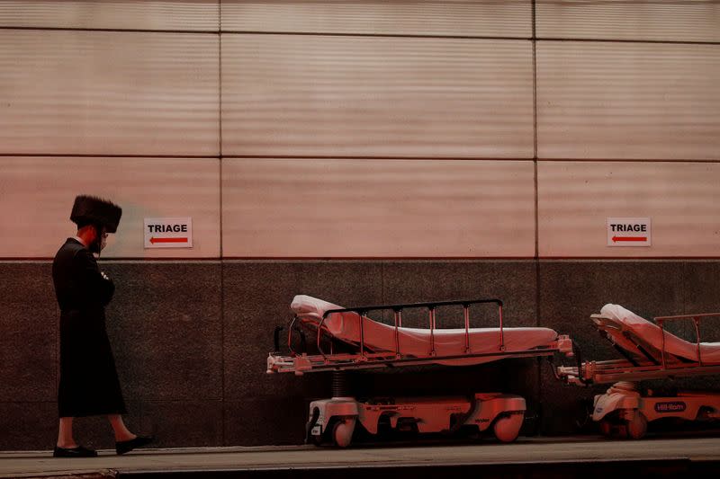 A member of the Hasidic Jewish community walks outside the emergency center at Maimonides Medical Center during the outbreak of the coronavirus disease (COVID19) in the Brooklyn, New York