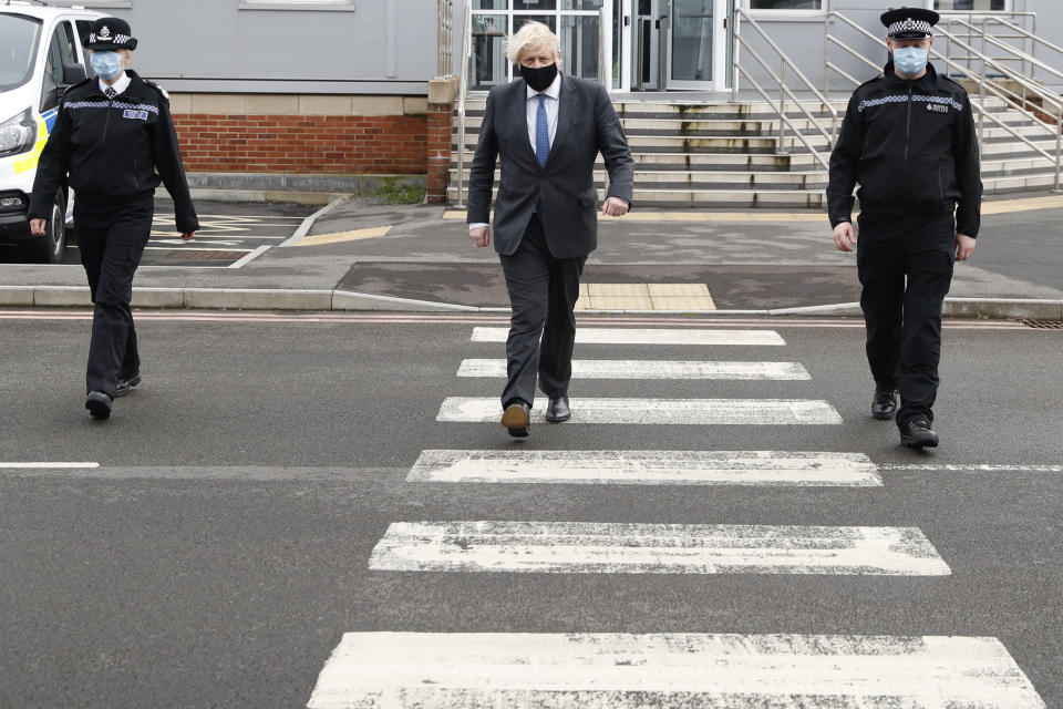 Prime minister Boris Johnson (centre) walking with police officers during a visit to South Wales Police Headquarters in Bridgend. Picture date: Wednesday February 17, 2021.