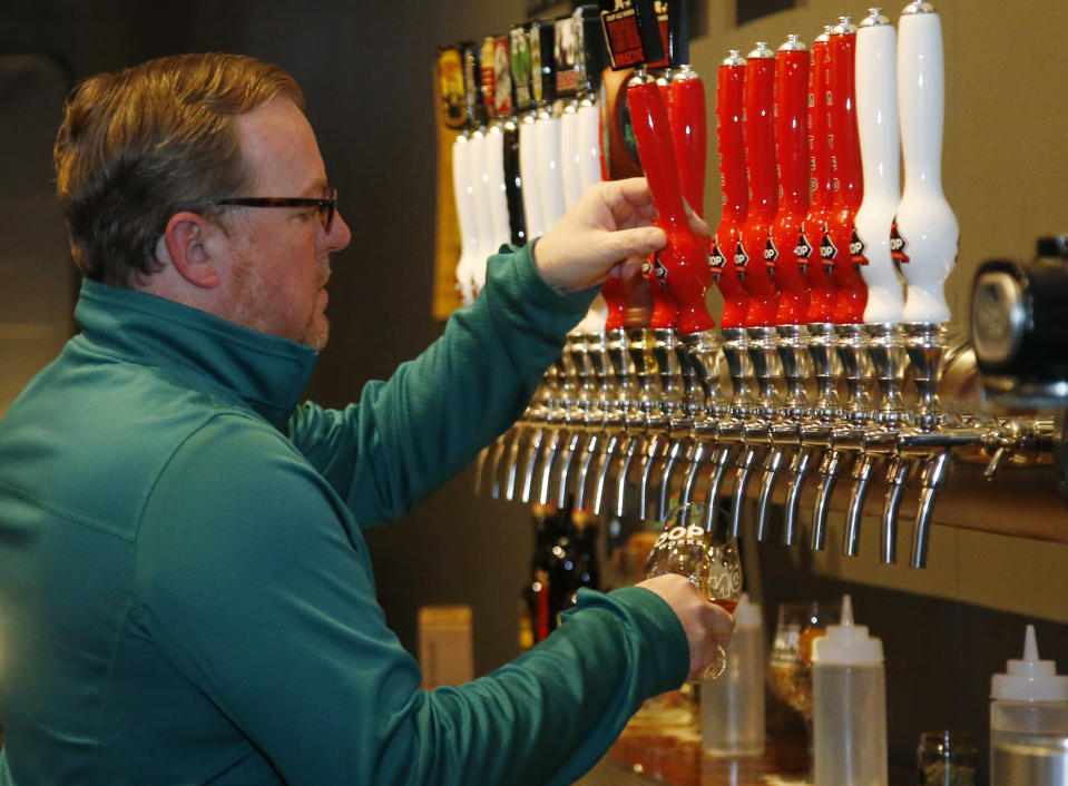 Sean Mossman, director of sales and marketing for COOP Ale Works, draws a beer in the COOP taproom in Oklahoma City, Friday, Jan. 18, 2019. Rules that went into effect in Oklahoma in October allow grocery, convenience and retail liquor stores to sell chilled beer with an alcohol content of up to 8.99 percent. Previously, grocery and convenience stores could offer only 3.2 percent beer. Liquor stores, where stronger beers were available, were prohibited from selling it cold. (AP Photo/Sue Ogrocki)