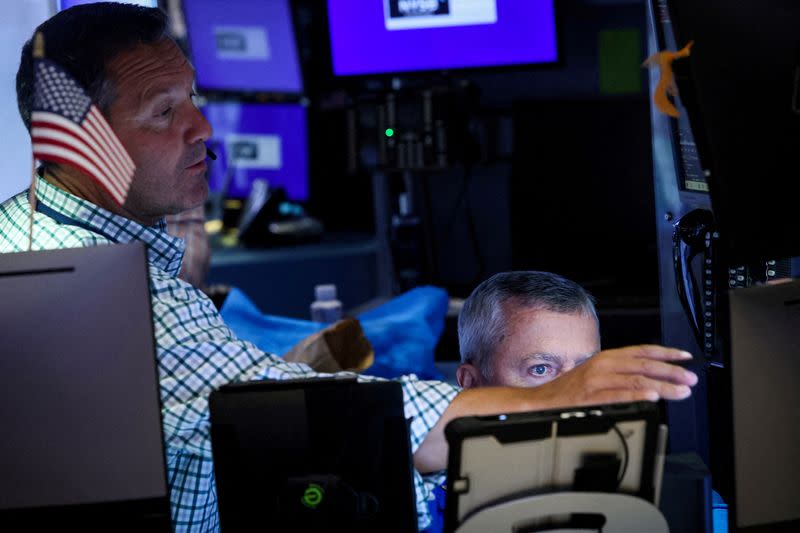 FILE PHOTO: Traders work on the floor of the NYSE in New York