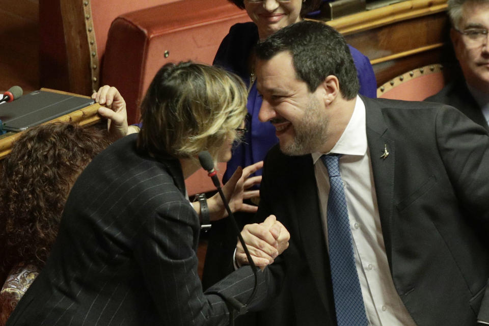 Opposition populist leader Matteo Salvini greets senator Giulia Bongiorno during the debate at the Italian Senate on whether to allow him to be prosecuted – as he demands to be -- for alleging holding migrants hostage for days aboard coast guard ship Gregoretti instead of letting them immediately disembark in Sicily, while he was interior minister. Salvini says being on trial for alleged kidnapping is tantamount to defending his country from illegal migrants he blames for crime and for subtracting jobs from Italians. (AP Photo/Andrew Medichini)