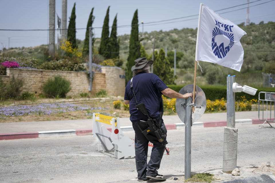 An Israeli security guard secures the entrance to the Jewish settlement of Ariel in the West Bank near the Palestinian city of Nablus, Saturday, April 30, 2022. The Israeli military says it is searching for a pair of Palestinian attackers who shot and killed a security guard at the entrance of a Jewish settlement in the occupied West Bank. The shooting took place late Friday at the entrance to Ariel, a major settlement in the northern West Bank. (AP Photo/Ariel Schalit)