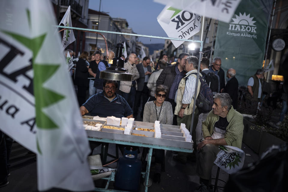 A street vendor and supporters of PASOK-Movement for Change (KINAL) listen to the leader of the party Nikos Androulakis during a pre election rally, in Athens, on Wednesday, May 17, 2023. Greeks go to the polls Sunday, May 21, in the first general election held since the country ended successive international bailout programs and strict surveillance period imposed by European leaders. Conservative Prime Minister Kyriakos Mitsotakis is seeking a second four-year term and is leading in opinions but may need a coalition partner to form the next government. (AP Photo/Petros Giannakouris)