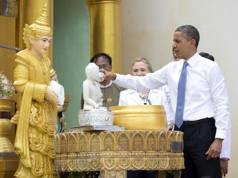 FILE - In this Nov. 19, 2012, photo, President Barack Obama "douses eleven flames" as he tours the Shwedagon Pagoda with Secretary of State Hillary Rodham Clinton in Yangon, Myanmar. Little noticed during Obama's landmark visit to Myanmar was a significant concession that could shed light on whether that nation's powerful military pursued a clandestine nuclear weapons program, possibly with North Korea's help. Myanmar announced it would sign an international agreement that would require it to declare all nuclear facilities and materials. Although it would be up to Myanmar to decide what to declare, it could provide some answers concerning its acquisition of dual-use machinery and military cooperation with North Korea. (AP Photo/Carolyn Kaster)