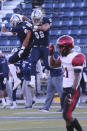 Diego State running back Chance Bell (21) walks off the field as Nevada running back (3) Jamaal Bell and defensive end Sam Hammond celebrate their win in an NCAA college football game Saturday, Nov. 21, 2020, in Reno, Nev. (AP Photo/Lance Iversen)