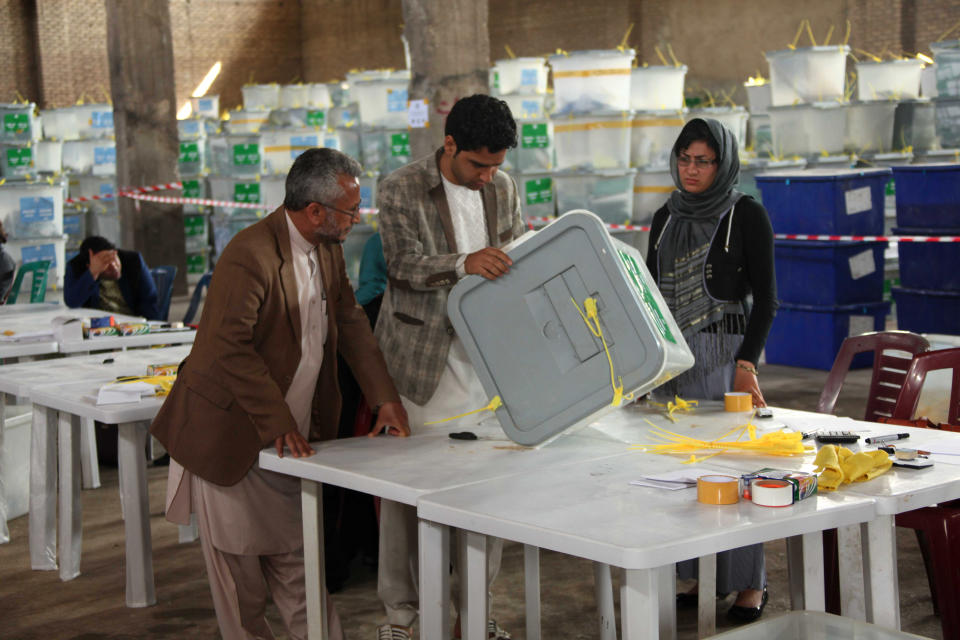 Afghan ballot counters read instructions on how to count and register votes in Herat Province, west of Kabul, Afghanistan, Sunday, April 20, 2014. New partial results in Afghanistan's presidential election released Sunday show candidate Abdullah Abdullah is still the front-runner, though a runoff election looks likely. (AP Photo/Hoshang Hashimi)