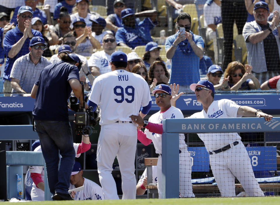 Los Angeles Dodgers starting pitcher Hyun-Jin Ryu (99) is greeted in the dugout by manager Dave Roberts, center, and bench coach Bob Geren at the end of the eighth inning of a baseball game against the Washington Nationals Sunday, May 12, 2019, in Los Angeles. (AP Photo/Marcio Jose Sanchez)