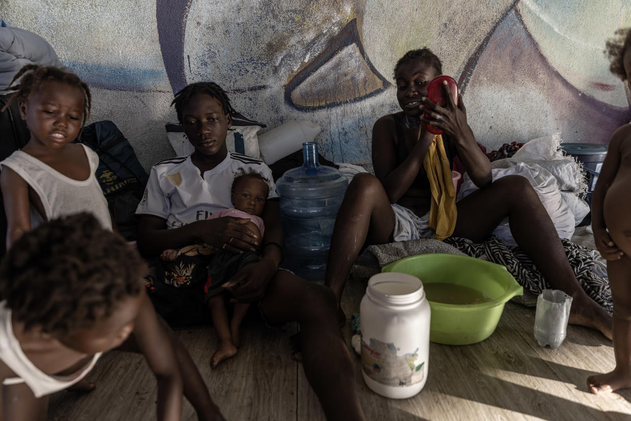 Personas descansan en el parque Hugo Chávez, cerca del aeropuerto, donde miles han llegado después de huir de la violencia en comunidades vecinas como Cité Soleil, en Puerto Príncipe, Haití, el 8 de noviembre de 2022. (Adriana Zehbrauskas/The New York Times)