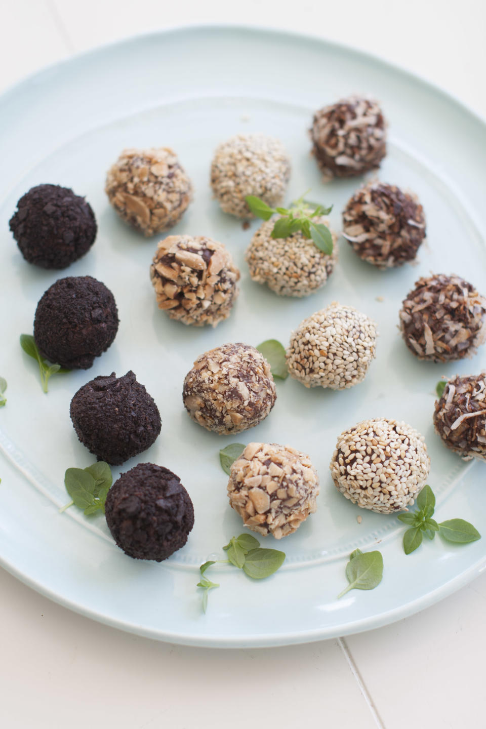 This March 24, 2014 photo shows a variety of basil tea truffles coated with, from left, chocolate wafer cookies, chopped marcona almonds, toasted sesame seeds, and toasted coconut, in Concord, N.H. (AP Photo/Matthew Mead)