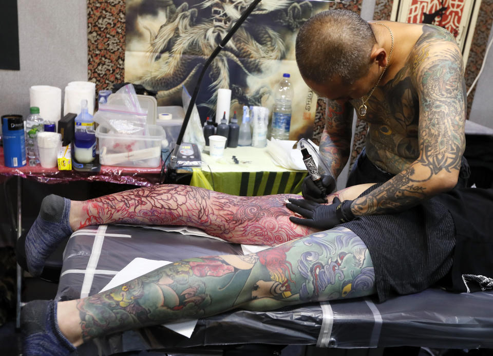 <p>A tattoo artist works at The International Tattoo Convention in London, Friday, Sept. 22, 2017. (Photo: Kirsty Wigglesworth/AP) </p>