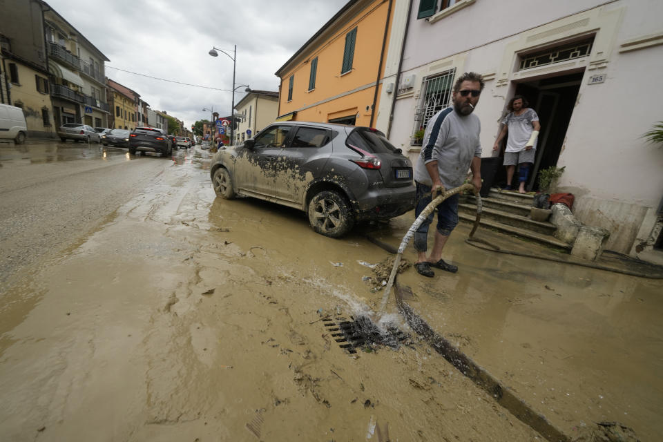 A man removes water from his flooded home in Castel Bolognese, Italy, Thursday, May 18, 2023. Exceptional rains Wednesday in a drought-struck region of northern Italy swelled rivers over their banks, killing at least nine people. Rescue crews worked Thursday to reach isolated towns and villages in northern Italy that were cut off from highways, electricity and cellphone service following heavy rains and flooding, as farmers warned of "incalculable" losses and authorities began mapping out cleanup and reconstruction plans. (AP Photo/Luca Bruno)