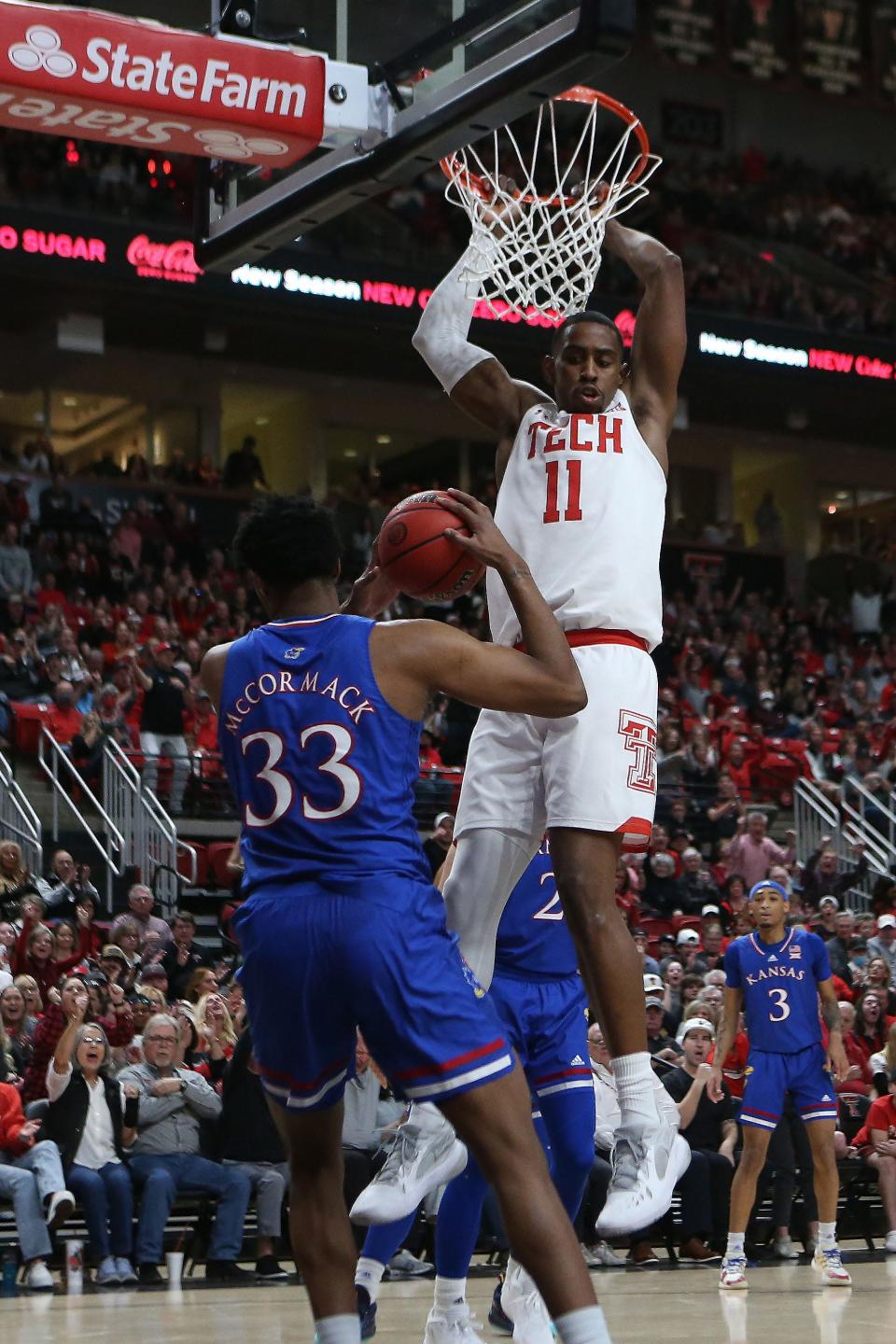 Texas Tech's Bryson Williams (11) hangs from the rim in front of Kansas' David McCormack (33) during the first half of a Big 12 Conference game Jan. 8 at United Supermarkets Arena. Williams finished with 22 points in the 75-67 win over the Jayhawks.