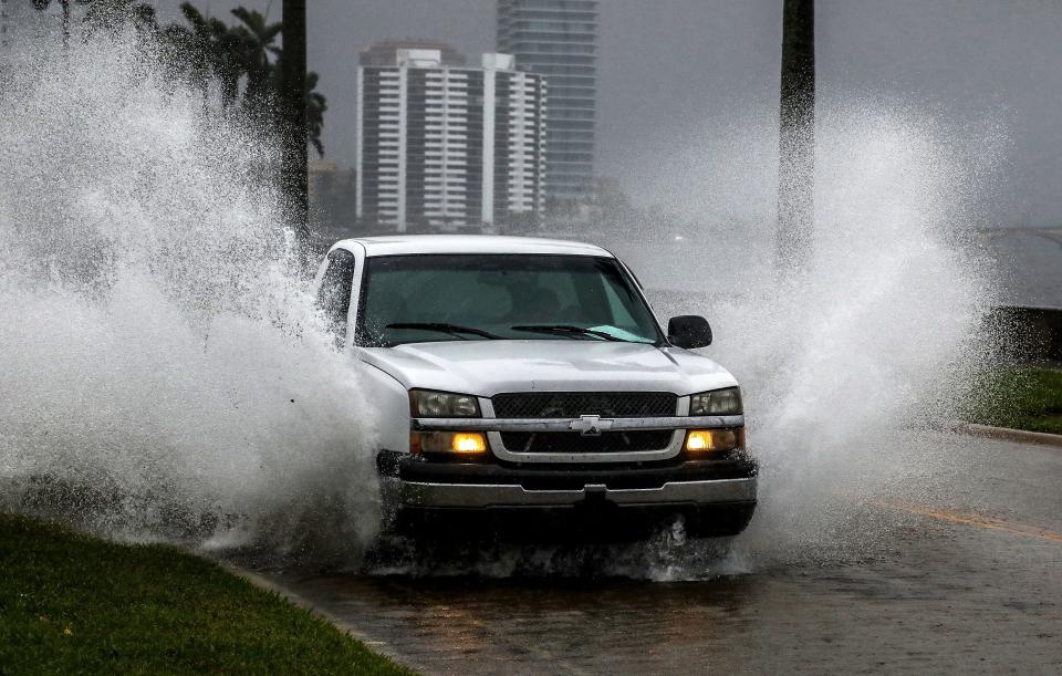 A truck splashes through a flooded portion of Flagler Drive near Valencia Road on Saturday in West Palm Beach. The storm that has now become Tropical Storm Alex brought record rainfall Saturday to Palm Beach County.