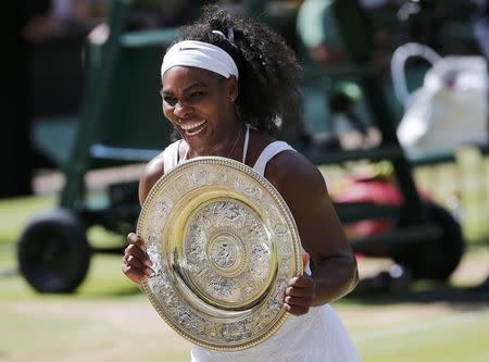 Serena Williams of the U.S.A shows off the trophy after winning her Women's Final match against Garbine Muguruza of Spain at the Wimbledon Tennis Championships in London, July 11, 2015. REUTERS/Suzanne Plunkett