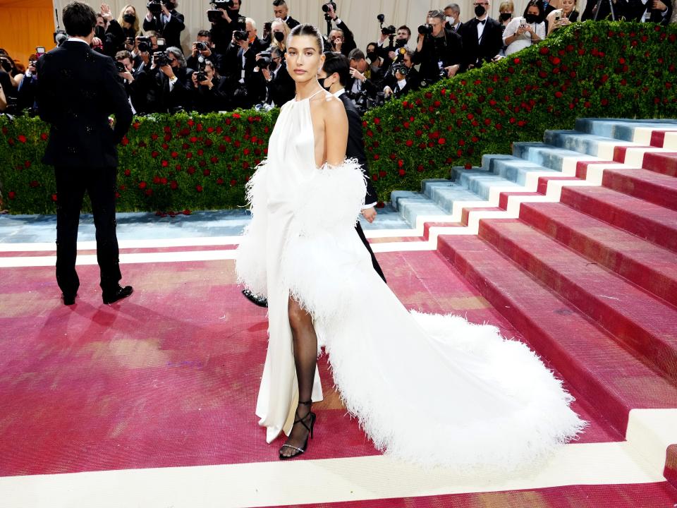 Hailey Bieber in white, feathered dress on red met gala steps