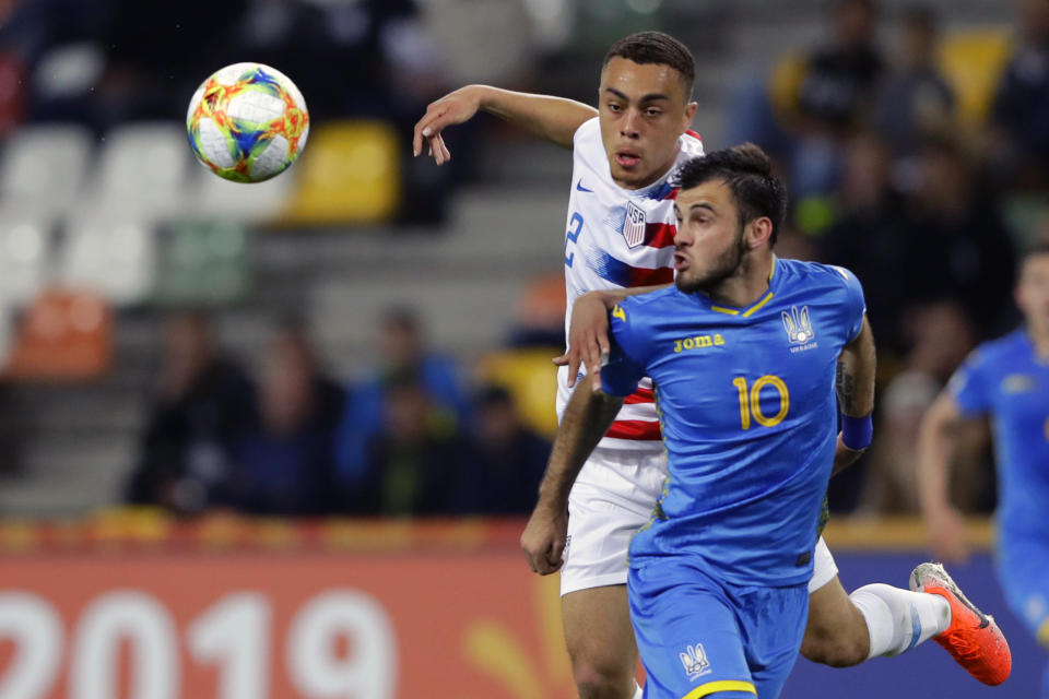 FILE - In this May 24, 2019 file photo, Ukraine's Serhii Buletsa, front, duels for the ball with United States' Sergino Dest during a Group D U20 World Cup soccer match in Bielsko Biala, Poland. Ajax right back Sergino Dest has pledged his international future to the United States. The 18-year-old, who has a Surinamese-American father and Dutch mother, put an end Monday, Oct 28, 2019 to intense speculation about whether he would choose to play for the United States or the Netherlands, his country of birth. (AP Photo/Sergei Grits, File)