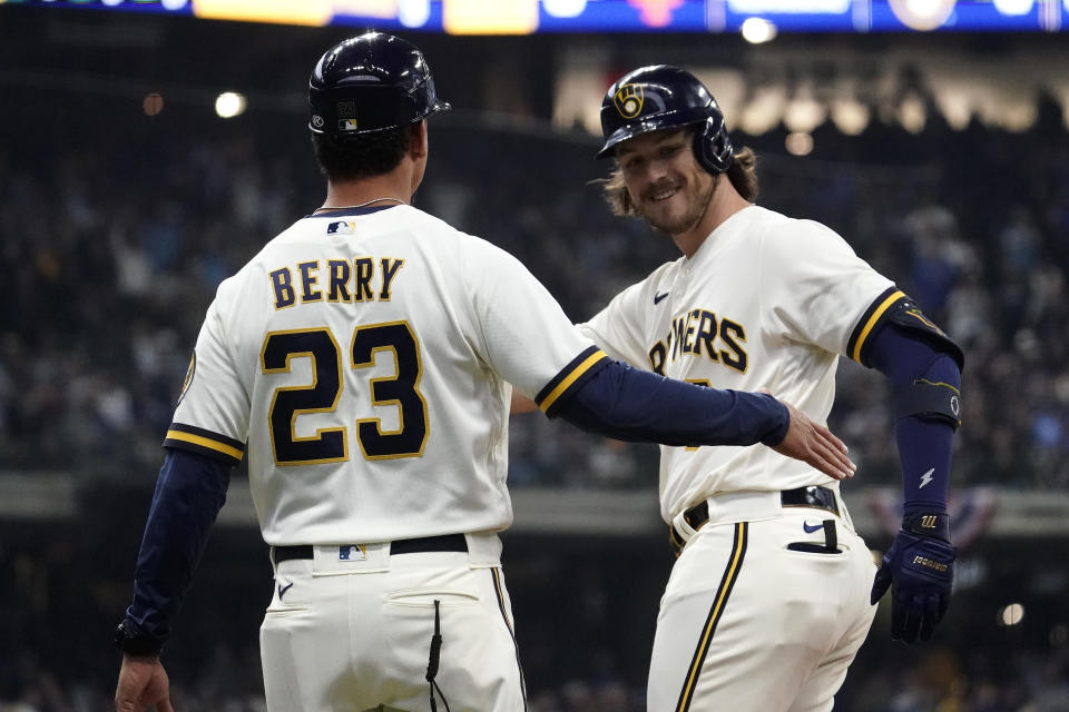 Milwaukee Brewers' Brian Anderson smiles with first base coach Quintin Berry (23) after hitting an RBI single during the fifth inning of a baseball game against the New York Mets Monday, April 3, 2023, in Milwaukee. (AP Photo/Aaron Gash)