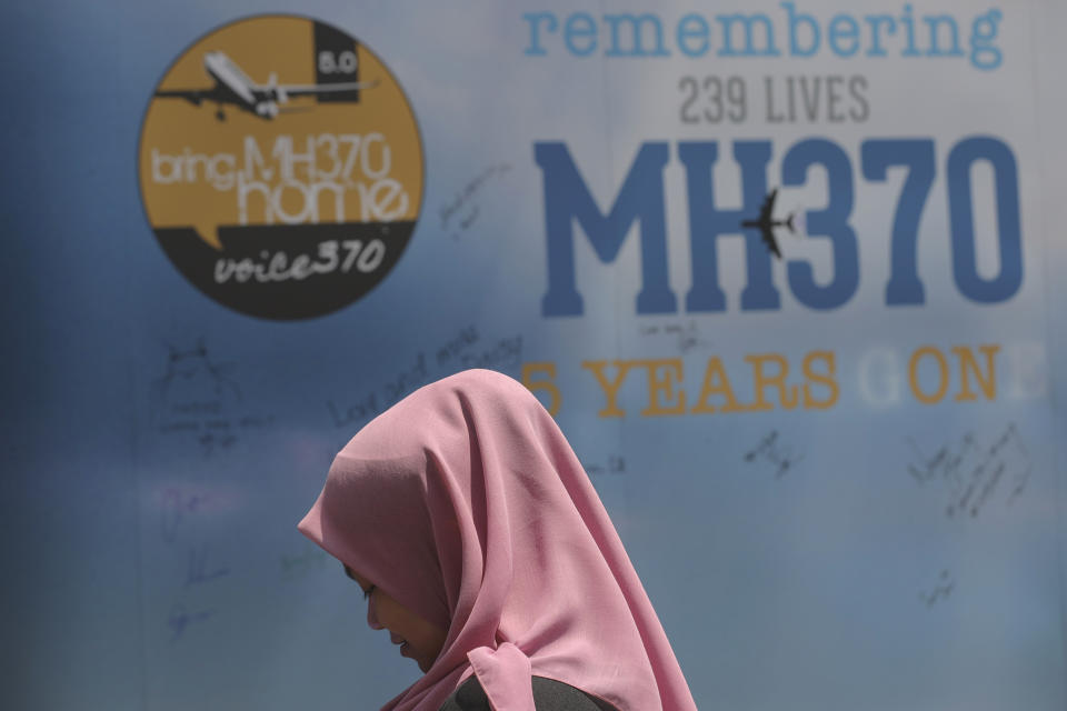 FILE - A girl stands in front of a condolence message board during a Day of Remembrance for MH370 event in Kuala Lumpur, Malaysia, on March 3, 2019. A decade ago this week, a Malaysia Airlines flight vanished without a trace to become one of aviation’s biggest mystery. Investigators still do not know exactly what happened to the plane and its 239 passengers. (AP Photo/Vincent Thian, File)