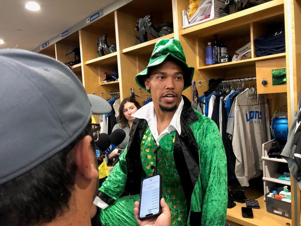 Detroit Lions wide receiver Amon-Ra St. Brown talks to reporters on Thursday afternoon in Allen Park dressed as a Notre Dame leprechaun following the loss by USC, his alma mater, to the Irish last weekend.
