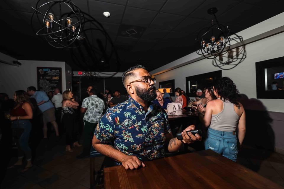 Delaware chef Reuben Dhanawade turns up the volume on a TV at Piccolina Toscana in Wilmington prior to watching an episode of the Food Network's reality show 'Chopped' where Reuben was a contestant.