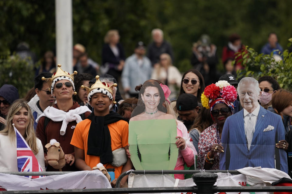 Fanáticos de la realeza británica sostienen unas imágenes del rey británico Carlos III, y de la princesa de Gales, Catalina, durante el desfile por el cumpleaños del rey en Londres, el sábado 15 de junio de 2024. (AP Foto/Alberto Pezzali)