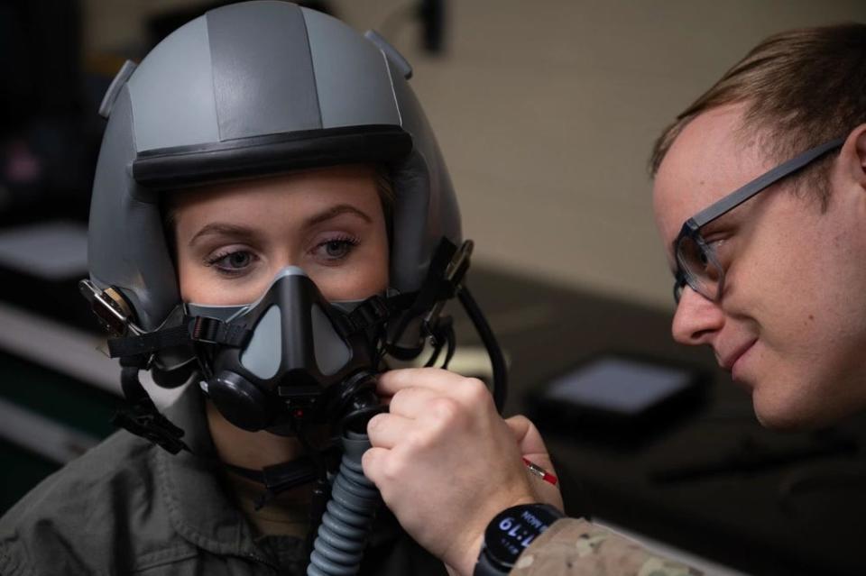 A pilot is fitted for a flight helmet