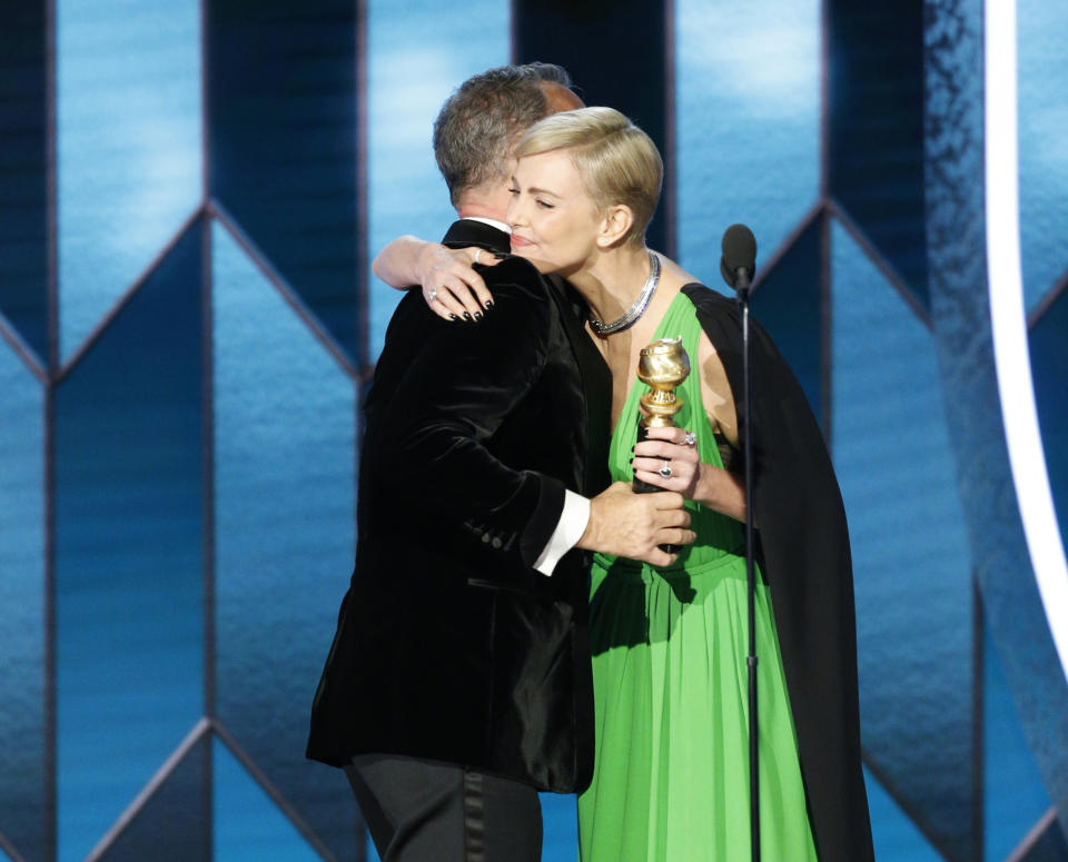 This image released by NBC shows Tom Hanks accepting the Cecil B. DeMille Award from presenter Charlize Theron at the 77th Annual Golden Globe Awards at the Beverly Hilton Hotel in Beverly Hills, Calif., on Sunday, Jan. 5, 2020. (Paul Drinkwater/NBC via AP)