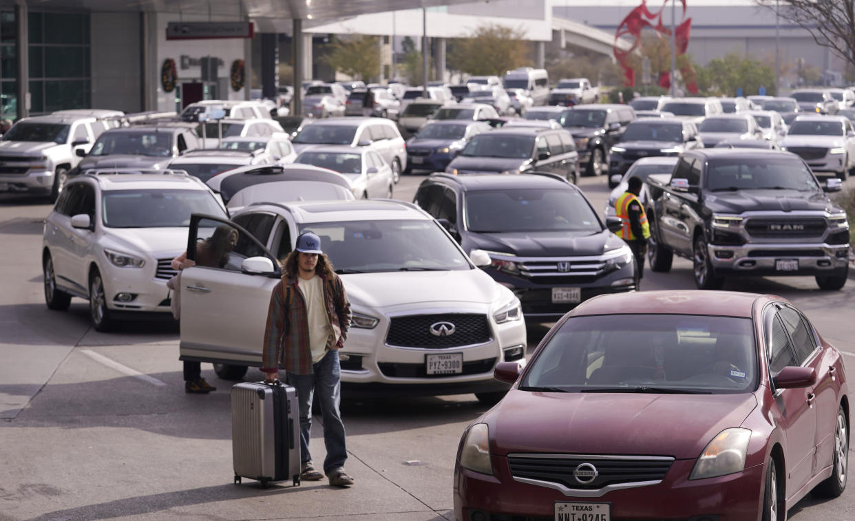 Cars line up to pick up travelers at Love Field Airport in Dallas, Wednesday, Dec. 21, 2022. (AP Photo/LM Otero)