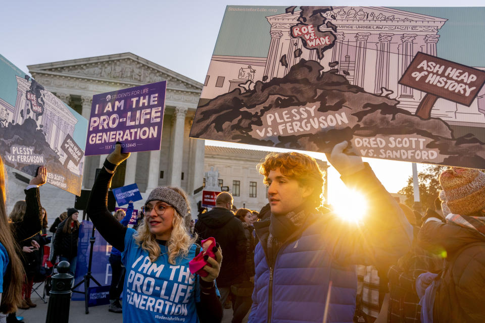 Anti-abortion protesters wear shirts that read "I am the Pro-Life Generation" and hold signs as they demonstrate in front of the U.S. Supreme Court, Wednesday, Dec. 1, 2021, in Washington, as the court hears arguments in a case from Mississippi, where a 2018 law would ban abortions after 15 weeks of pregnancy, well before viability. (AP Photo/Andrew Harnik)