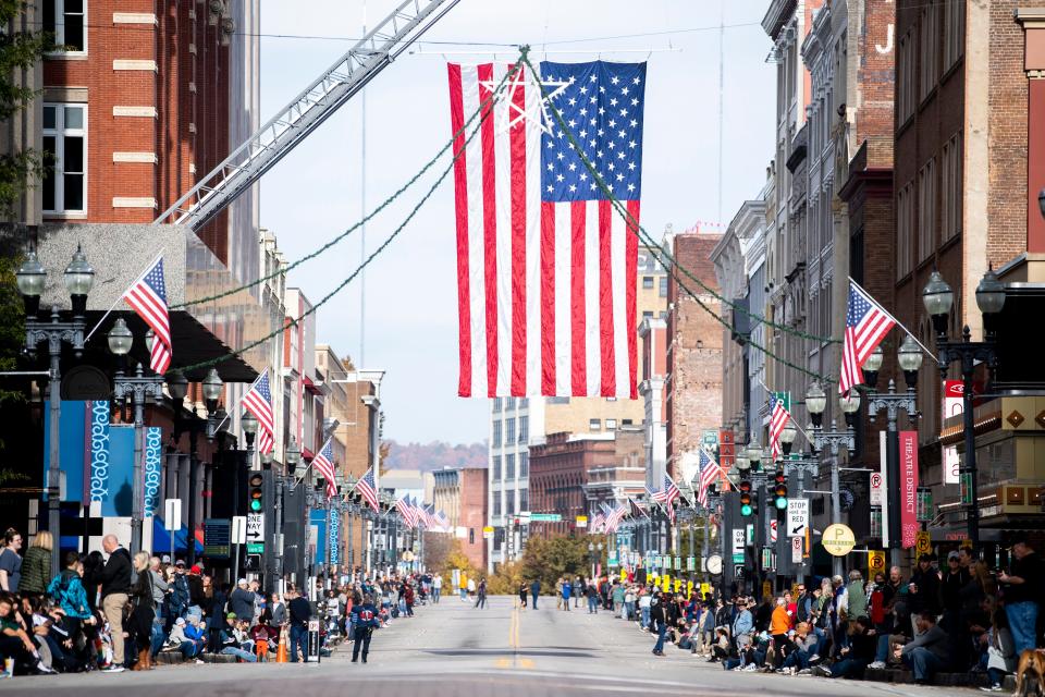 A large American Flag hangs over Gay St. during the 2021 Veterans Day Parade held in downtown Knoxville on Thursday, Nov. 11, 2021.