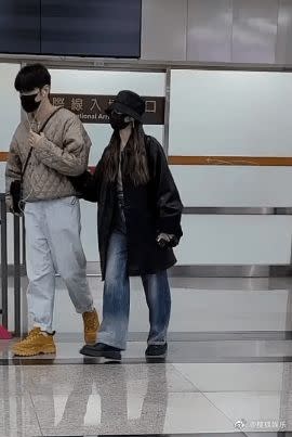 ▲李榮浩（左）及楊丞琳（右）一起現身松山機場，兩人全程戴著黑色口罩，女方則整路緊勾著李榮浩的手。（圖／翻攝自搜狐娛樂微博）