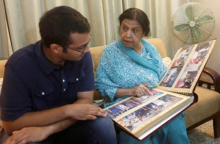 Rehana Khursheed Hashmi, 75, migrated from India with her family in 1960 and whose relatives, live in India, speaks with her grandson Zain Hashmi, 19 while looking family photo album at her residence in Karachi, Pakistan August 7, 2017. Picture taken August 7, 2017/REUTERS/Akhtar Soomro