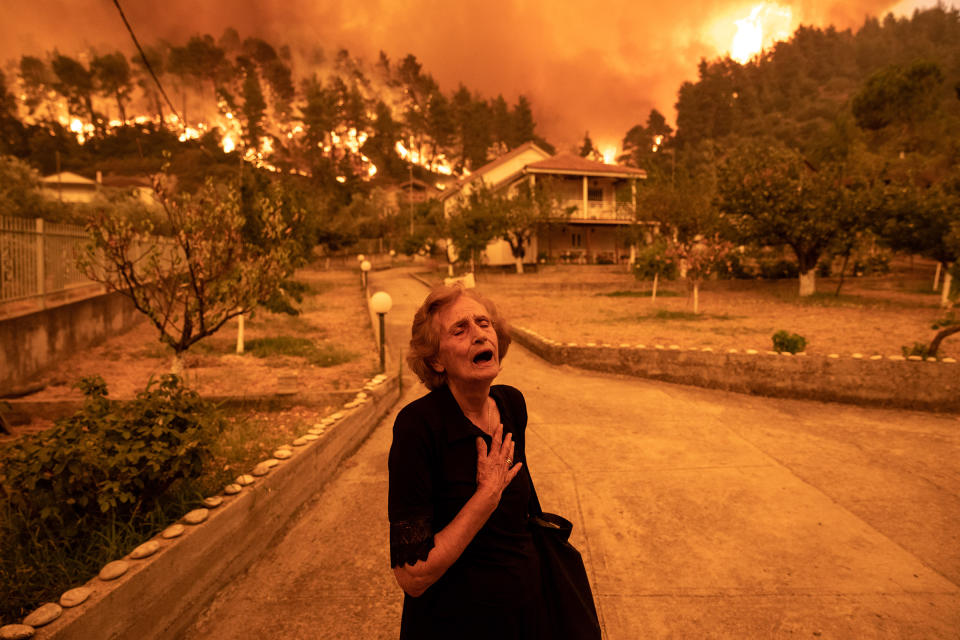 On the Greek island of Evia, wildfires resulting from the country’s worst heat wave in three decades approach the home of Ritsopi Panayiota, 81, on Aug. 8.<span class="copyright">Konstantinos Tsakalidis—Bloomberg/Getty Images</span>