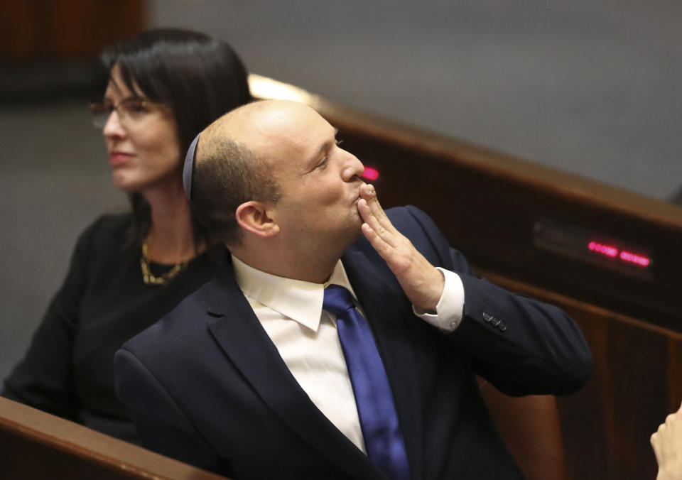 Israel's designated new prime minister Naftali Bennett sends greetings during a Knesset session in Jerusalem Sunday, June 13, 2021. Bennett is expected later Sunday to be sworn in as the country's new prime minister, ending Prime Minister Benjamin Netanyahu's 12-year rule. (AP Photo/Ariel Schali22