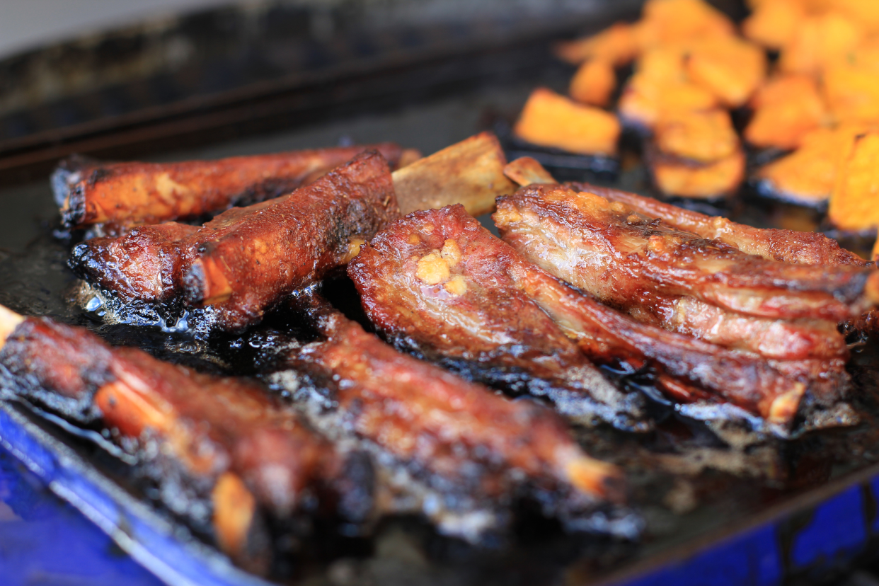 A Metal Tray of Overcooked BBQ Meat and Sweet Potatoes, Selective Focus