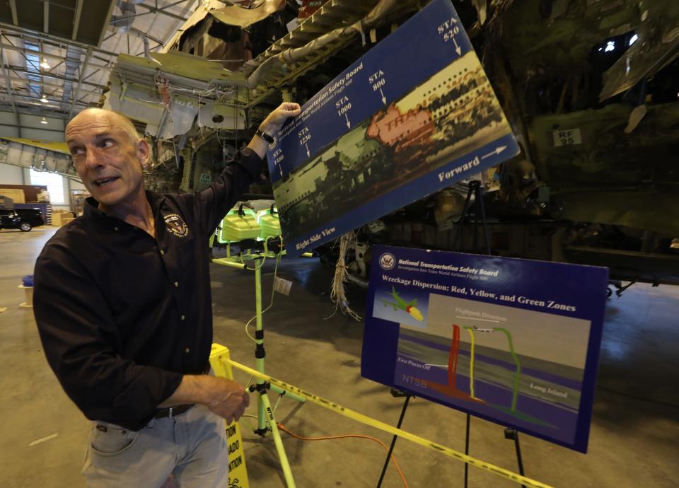 Frank Hilldrup, chief technical adviser for National Transportation Safety Board, moves posters that interpret a section of the Boeing 747 fuselage that exploded while the plane carried TWA Flight 800 fuselage. The fuselage is stored in a large laboratory at a George Washington University campus in Ashburn, Virginia on July 6, 2021.