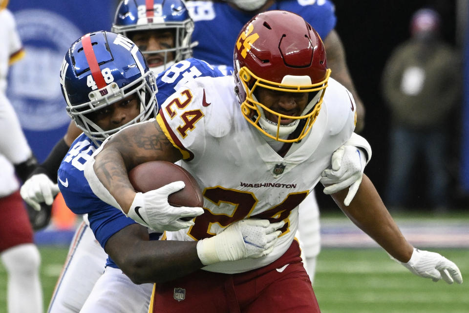 Washington Football Team running back Antonio Gibson (24) is tackled by New York Giants inside linebacker Tae Crowder (48) during the second quarter of an NFL football game, Saturday, Jan. 9, 2021, in East Rutherford, N.J. (AP Photo/Bill Kostroun)