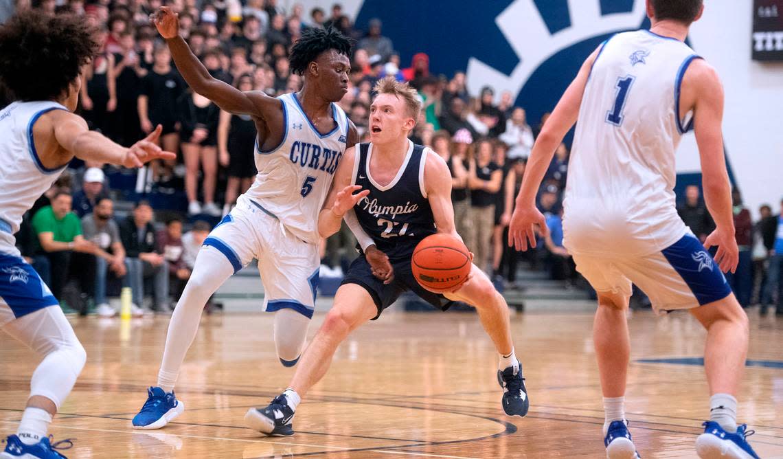 Olympia’s Parker Gerrits squares off against Curtis’ Zoom Dialo during Saturday night’s 4A SPSL boys basketball tournament championship game at Tacoma Community College in Tacoma, Washington, on Feb. 4, 2023.