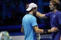 Italy's Matteo Berrettini, left, is comforted by Germany's Alexander Zverev after he had an injury during their ATP World Tour Finals singles tennis match, at the Pala Alpitour in Turin, Sunday, Nov. 14, 2021. (AP Photo/Luca Bruno)