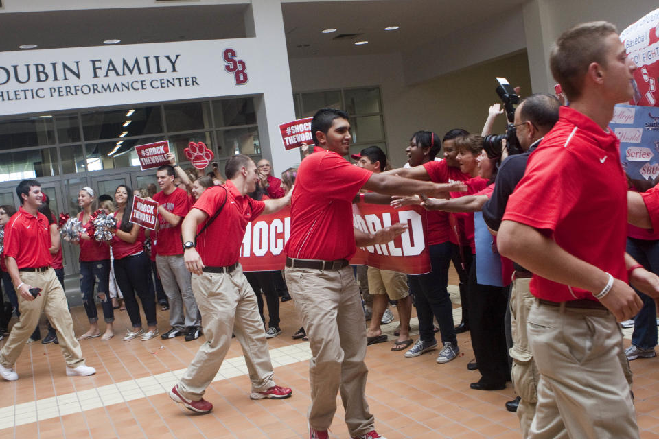 In this photo provided by Stony Brook University, members of the Stony Brook University men’s baseball team are “sent-off” by supporters as they leave for Omaha, Nebraska to compete in the men’s College Baseball World Series, Wednesday, June 13, 2012 in Stony Brook, N.Y. (AP Photo/Stony Brook University, John Griffin)