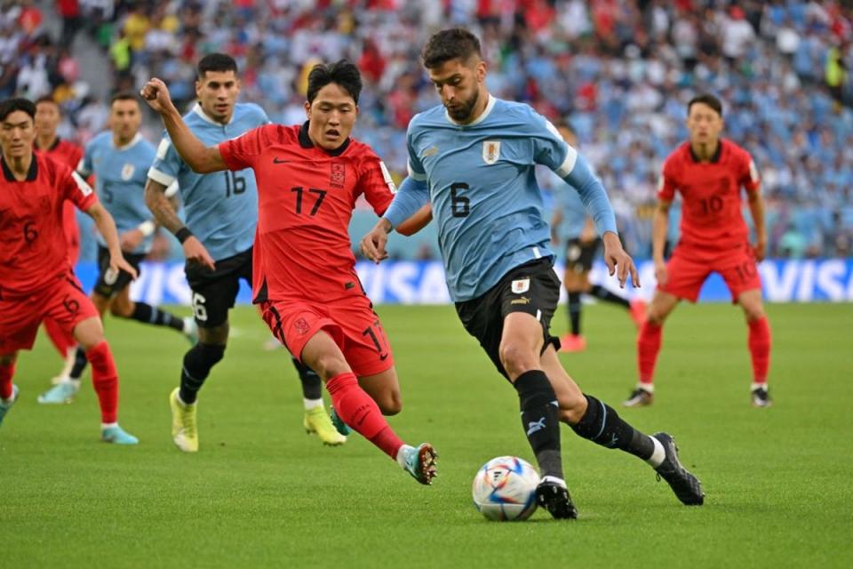 Rodrigo Bentancur runs with the ball past South Korea's midfielder Na Sang-ho (AFP via Getty Images)