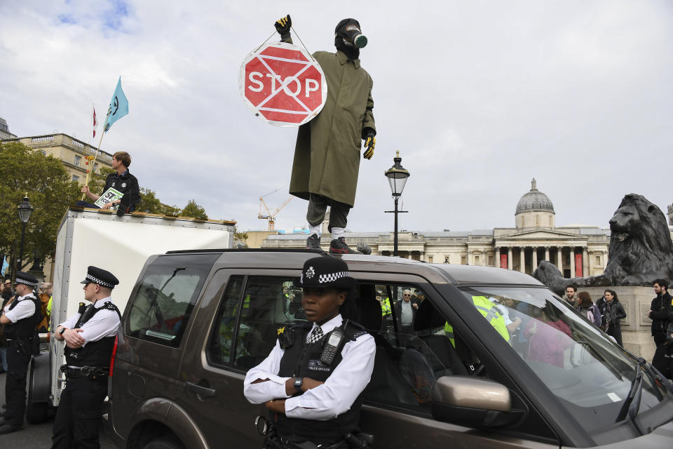 A climate activist stands on the roof of a car during an Extinction Rebellion Protest in London, Monday, Oct. 7, 2019. (Photo: Alberto Pezzali/AP)