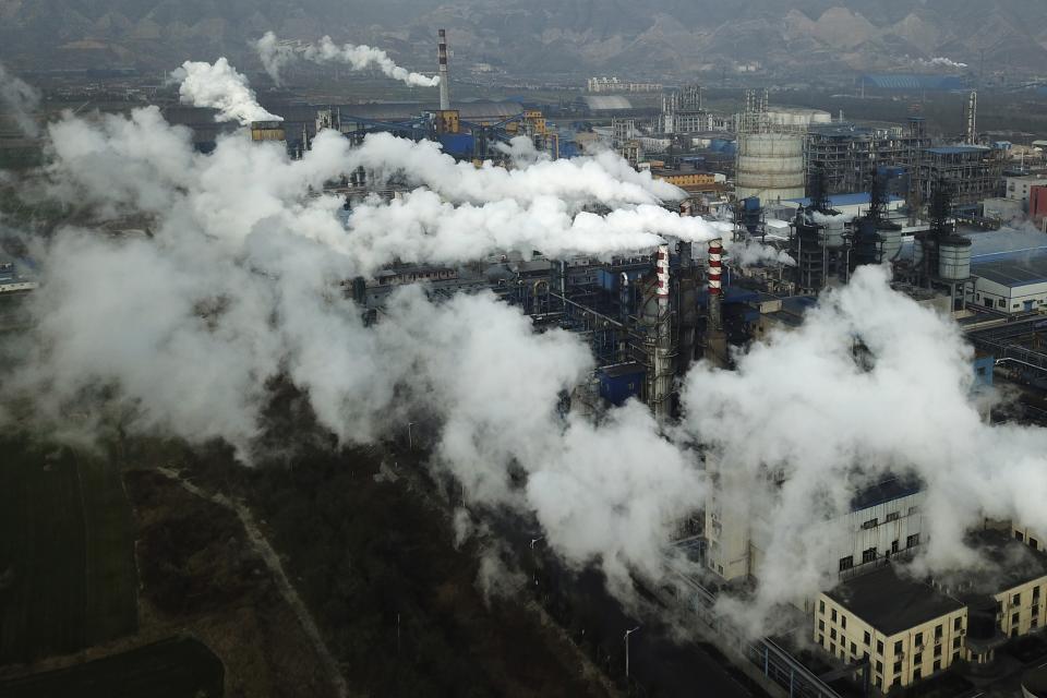 FILE - In this Nov. 28, 2019 file photo, smoke and steam rise from a coal processing plant that produces carbon black, an ingredient in steel manufacturing, in Hejin in central China's Shanxi Province. Scientists say greenhouse gas emissions must start dropping sharply as soon as possible to prevent global temperatures rising more than 1.5 degrees Celsius (2.7 degrees Fahrenheit) by the end of the century. So far, the world is on course for a 3- to 4-degree Celsius rise, with potentially dramatic consequences for many countries. (AP Photo/Sam McNeil, File)