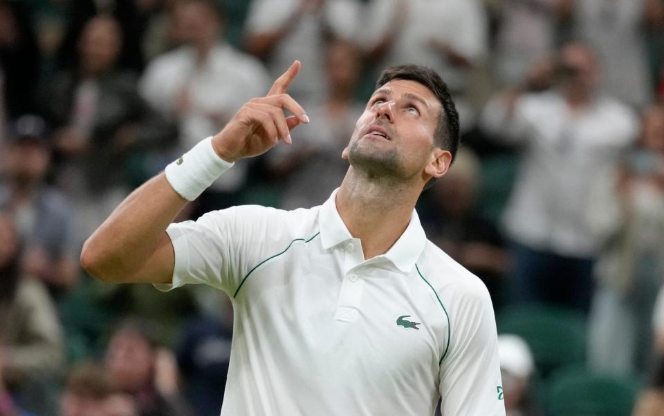Novak Djokovic points towards the Wimbledon roof - AP