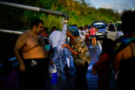 <p>People who lost access to water in the wake of Hurricane Maria gather at pipes carrying water from a mountain creek, on the side of the road in Utuado, Puerto Rico, Saturday, Oct. 14, 2017. (Photo: Ramon Espinosa/AP) </p>