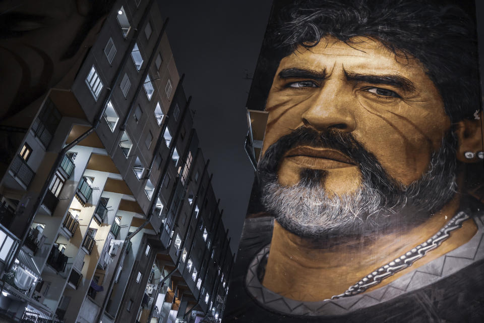 A giant mural of Diego Armando Maradona stands out in Naples, Italy, Wednesday, Nov. 24, 2021 hours ahead of the first anniversary of his death. Former Argentine soccer star Diego Maradona died of a heart attack on Nov. 25, 2020 at the age of 60, two weeks after being released from an Argentine hospital following brain surgery. (Alessandro Garofalo/LaPresse via AP)