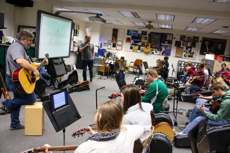 Matt Gerry (left) leads his advanced guitar class through Ben E. King's "Stand By Me," as Daniel Neihoff sings along.