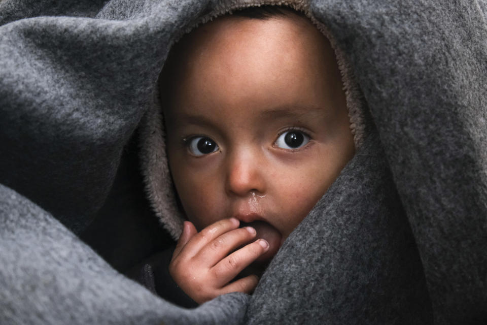 A migrant baby is wrapped in a blanket in the village of Skala Sikaminias, on the Greek island of Lesbos, after crossing on a dinghy the Aegean sea from Turkey on Thursday, March 5, 2020. Turkey said Thursday it would deploy special forces along its land border with Greece to prevent Greek authorities from pushing back migrants trying to cross into Europe, after Turkey declared its previously guarded gateways to Europe open. (AP Photo/Alexandros Michailidis)