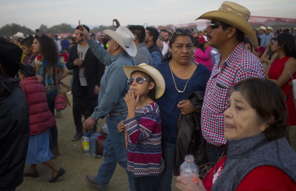 A family attends a party honoring Rubi Ibarra during celebrations for her down-home 15th birthday near the village of Laguna Seca, San Luis Potosi State, Mexico, Monday Dec. 26, 2016. Rubi's 15th birthday party resembled a rock concert on Monday after thousands of people showed up in response to an invitation by her father that went viral and made her the toast of the country. (AP Photo/Enric Marti)