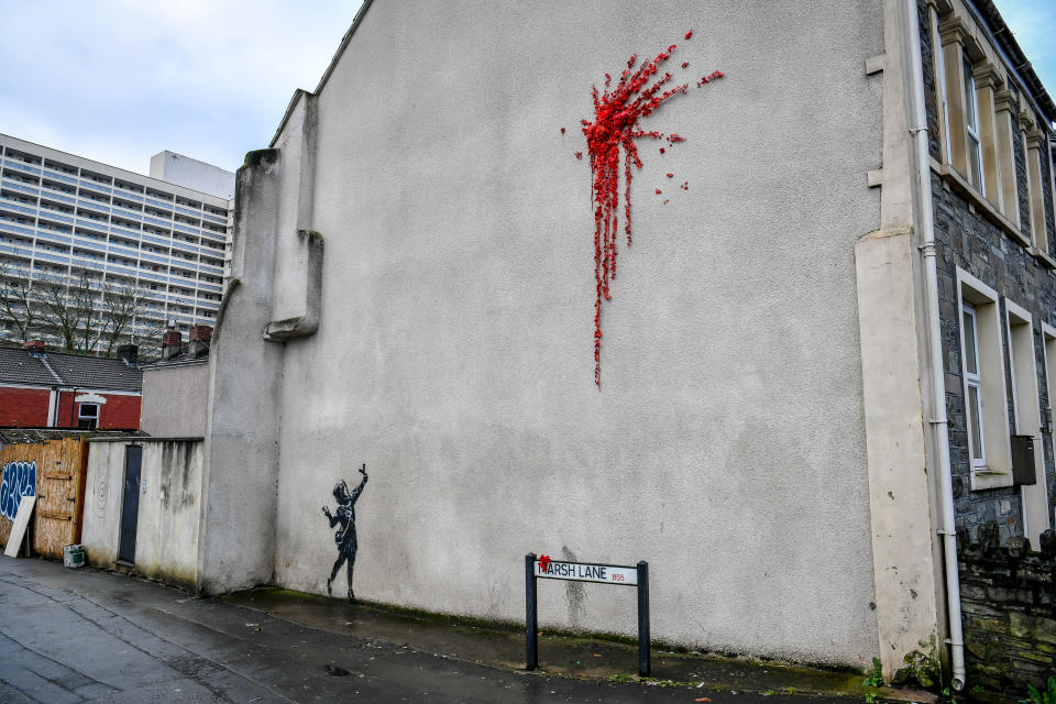 L'ultima creazione dello street artist britannico sulla facciata di un edificio a Bristol, sua città natale in Inghilterra: una bambina con una fionda di fronte a un’esplosione rossa, fatta di petali e fiori di plastica, forse il cuore infranto di Cupido. (Photo by Ben Birchall/PA Images via Getty Images)